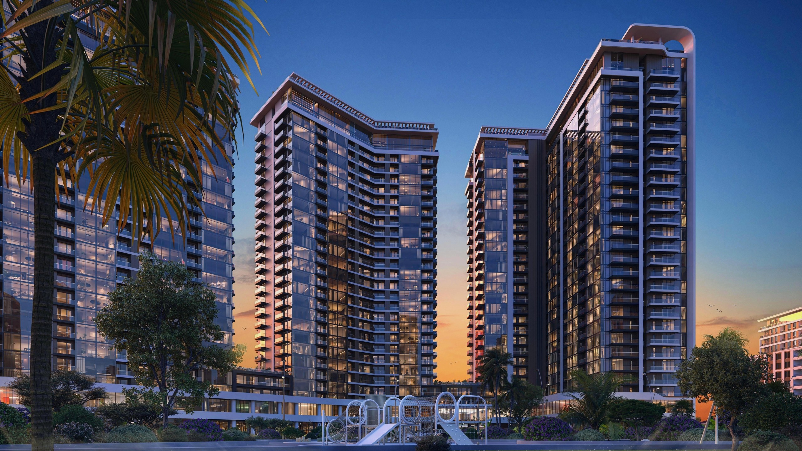 Архитектурная 3D-визуализация современного жилого комплекса с высотными зданиями, панорамным остеклением и благоустроенной придомовой территорией в вечернее время.