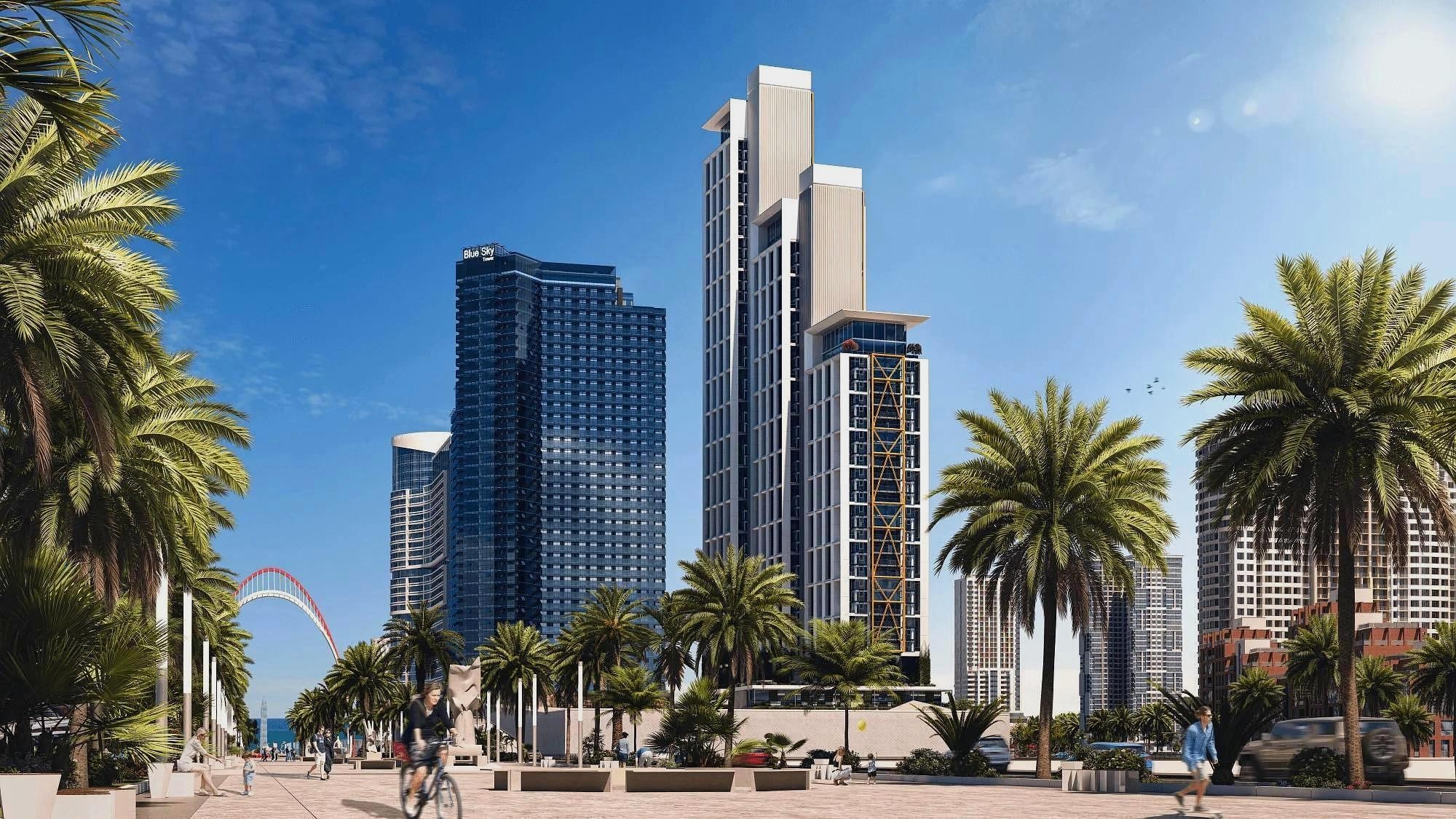 Архитектурный 3D-рендер, демонстрирующий внешний вид высотного жилого комплекса и благоустроенную прогулочную зону с пальмами.