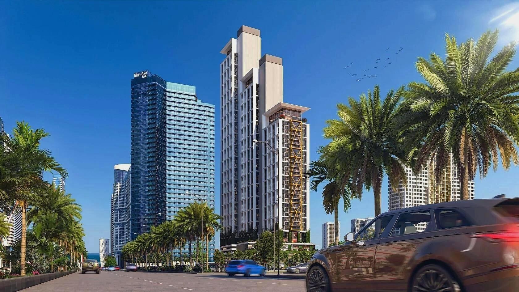 Реалистичная 3D-визуализация экстерьера современного жилого комплекса с высотными зданиями, пальмами и автомобилями на переднем плане.