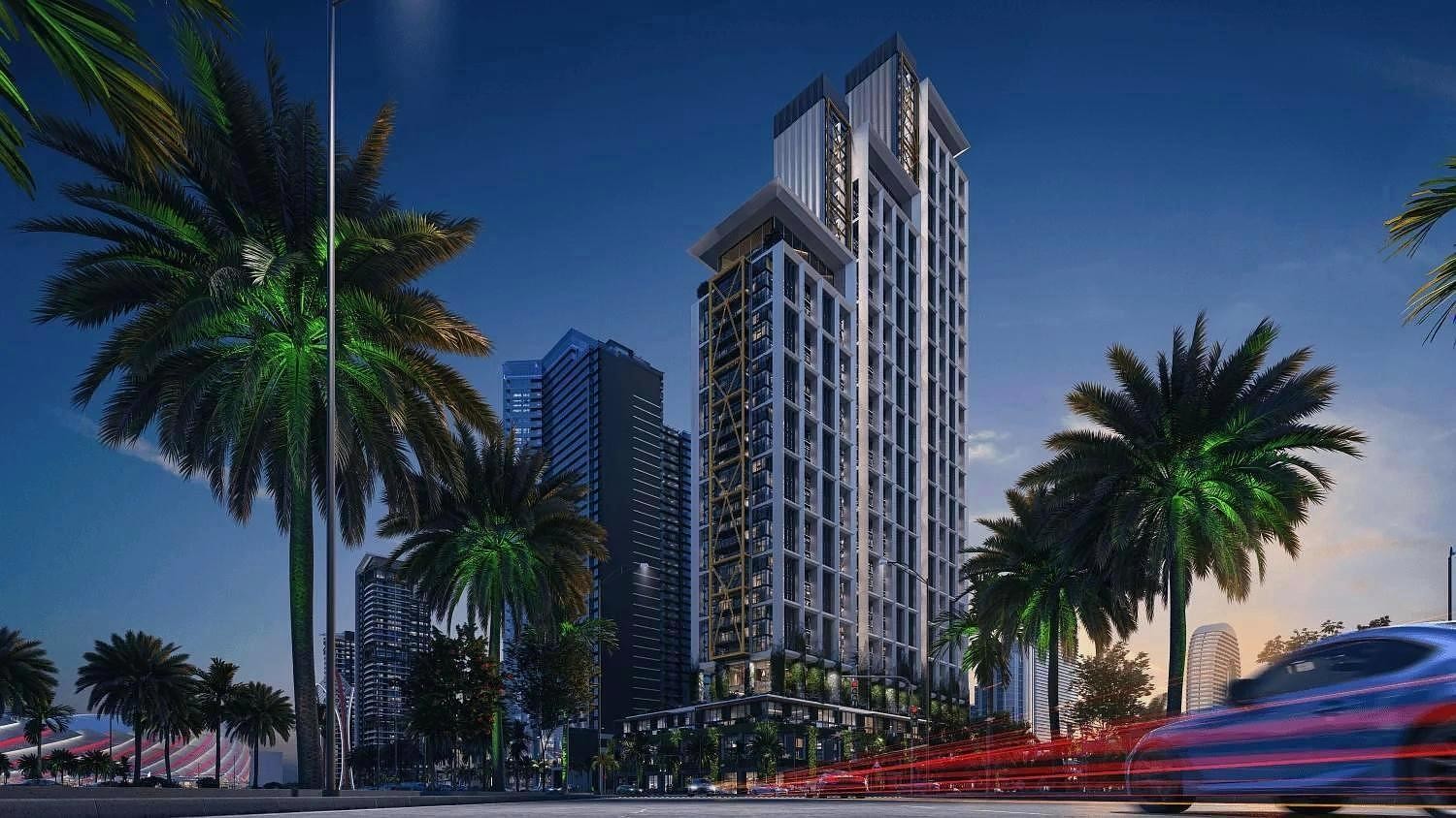 На изображении представлен ночной 3D-рендер современного высотного жилого комплекса с архитектурной подсветкой, окруженного пальмами и дорогой с эффектом движения автомобилей.