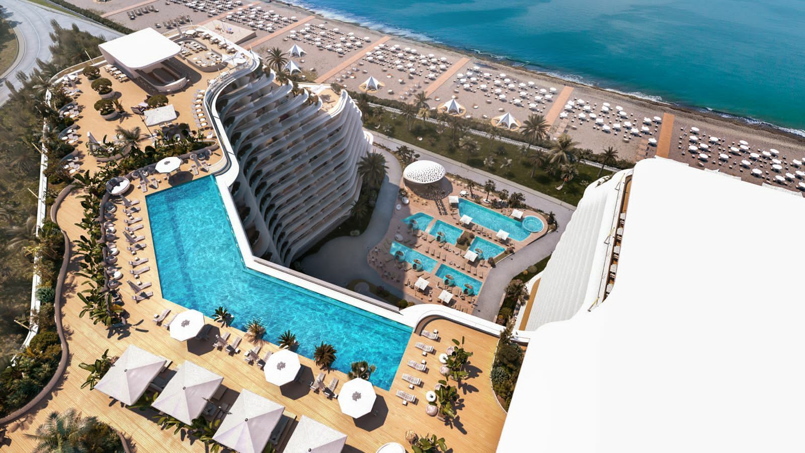 На изображении представлен 3D-рендер роскошного курортного комплекса с видом сверху, демонстрирующий архитектуру здания, бассейны на террасе и благоустроенный пляж.