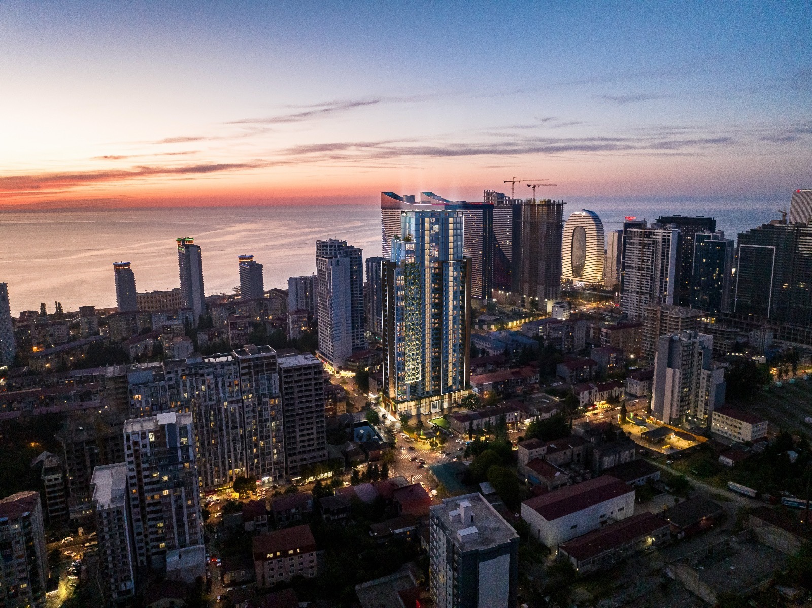 Архитектурная 3D-визуализация высотного жилого комплекса, вписанная в реальную панораму вечернего прибрежного города.