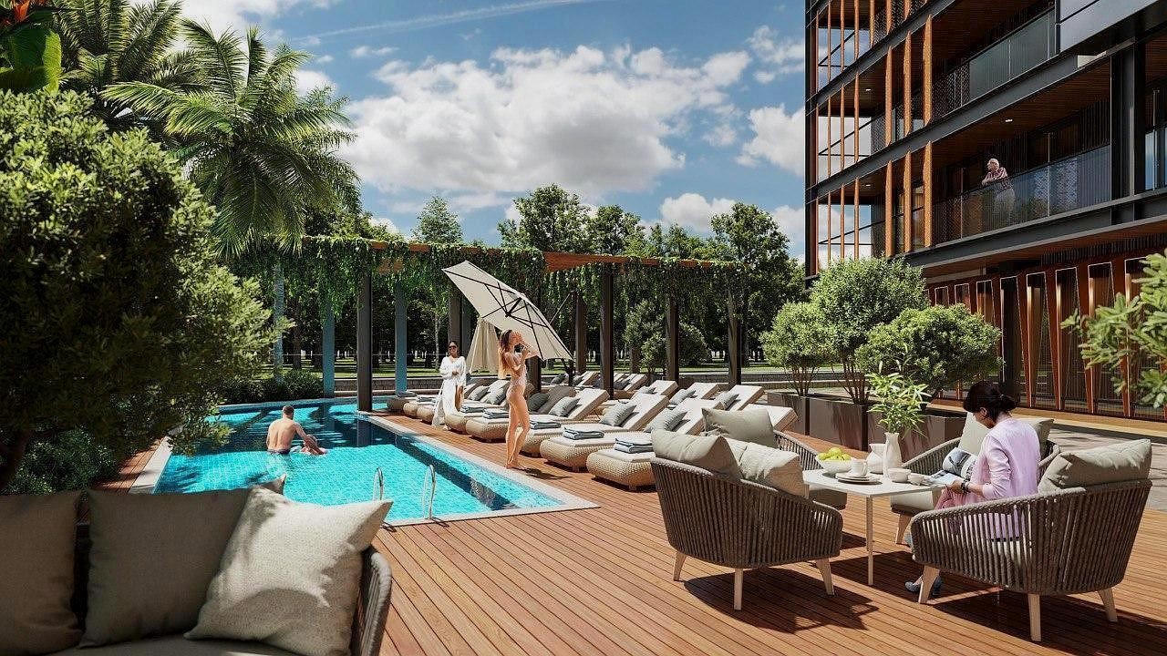 3D-визуализация зоны отдыха на территории жилого комплекса, включающая открытый бассейн, деревянную террасу с шезлонгами и места для досуга.